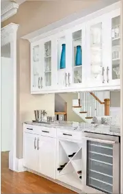  ?? PHOTOS CONTRIBUTE­D BY ASHTON WOODS ?? Display cabinetry, wine storage and an under-counter fridge make this beverage bar a functional and attractive part of a kitchen.