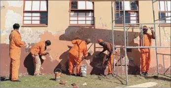  ?? PICTURE: NEIL BAYNES ?? AT WORK: Prisoners in Mthatha repaint Qunu Primary School on Mandela Day last year.