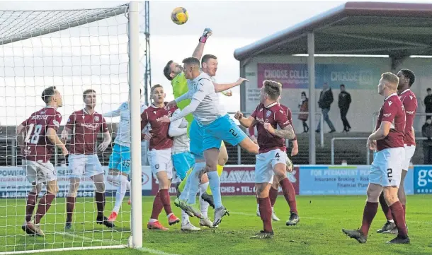  ?? ?? BATTLE: Arbroath’s Derek Gaston attempts to punch clear under pressure from Inverness’s Shane Sutherland in the tough conditions at Gayfield.