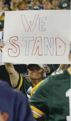  ?? MIKE ROEMER/THE ASSOCIATED PRESS ?? Packers quarterbac­k Aaron Rodgers asked fans to link arms Thursday night before the Bears game as a sign of unity. Some fans had other signs.