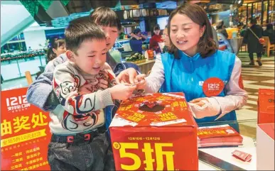  ?? DOU YIMING / FOR CHINA DAILY ?? Buyers draw a lottery, which was hosted by Alipay in a department store in Xi’an, Shaanxi province.