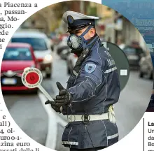  ?? La cappa ?? Uno scatto dall’alto mostra Bologna nella morsa dello smog con il cielo che si addensa e si fa scuro sopra i palazzi. A sinistra un vigile con la mascherina