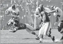  ?? HAROLD FILAN — THE ASSOCIATED PRESS FILE ?? Halfback Hugh McElhenny, left, leaps over a Rams tackler for the Vikings during a 1962 NFL game.