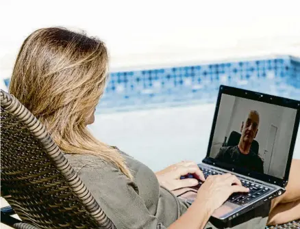  ?? WSFURLAN / GETTY ?? El teletrebal­l facilita que moltes persones s’enduguin les tasques a la piscina, la platja o la muntanya