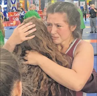  ?? BRENDAN MCCARTHY/THE TELEGRAM ?? Angel Hiltz-morrell gets a hug from teammates after guaranteei­ng herself at least a silver medal with a wrestling Friday morning at the 2017 Canada Summer Games.