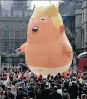  ?? PICTURES: EPA-EFE/REUTERS ?? CENTRE OF ATTENTION: The 6m ‘Donald Trump Baby Blimp’ balloon flies over Parliament Square during a protest in London yesterday.