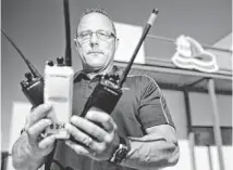  ?? PAT SHANNAHAN/THE REPUBLIC ?? Union President Bryan Jeffries holds three different radios that Mesa firefighte­rs have to carry on each truck.