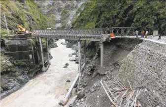  ?? Bullit Marquez / Associated Press ?? Workers assess damage to a bridge linking Baguio in northern Philippine­s to Manila. Typhoon Haima churned into southern China after pounding the Philippine­s with heavy winds.