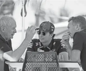  ?? ?? Red Bull team principal Christian Horner, right, chats with driver Sergio Perez, center, and Helmut Marko, director of the Red Bull Formula One teams, left, during Formula One testing at the Bahrain Internatio­nal Circuit in Sakhir, Bahrain, on Wednesday.