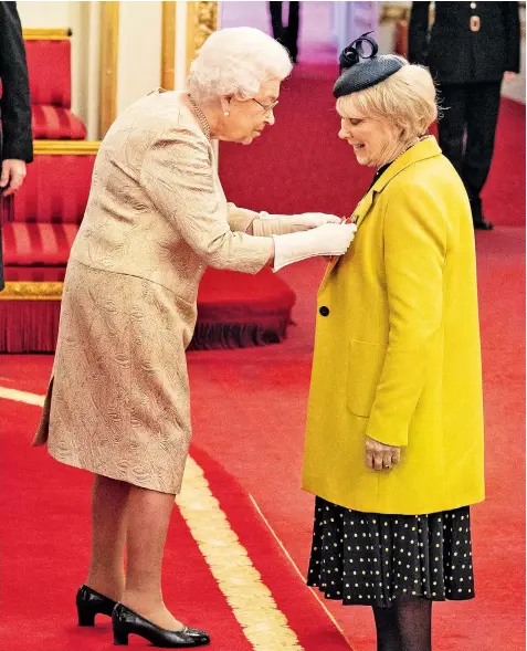  ??  ?? The Queen wears gloves, amid concern about the spread of coronaviru­s, as she presents actress Wendy Craig with a CBE at an investitur­e ceremony at Buckingham Palace yesterday