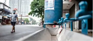  ?? Associated Press ?? ↑
A man walks past a hand wash facility installed on a roadside in Kochi on Thursday.