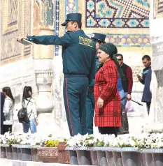  ??  ?? Members of a newly-formed Tourist Police helping a woman in the famed silk road city of Samarkand.