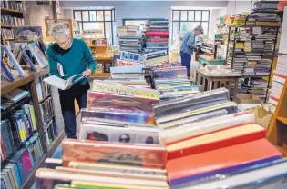  ?? EDDIE MOORE/JOURNAL ?? Customer Jim Bradbury peruses the stacks of books for sale at op.cit. in Santa Fe. “It’s still a life of genteel poverty,” says store owner Noemi de Bodisco.
