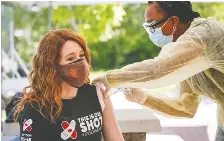  ?? JEFF MCINTOSH/THE CANADIAN PRESS ?? Olympic medallist Clara Hughes, left, receives a shot at the Stoney Nakoda First Nation clinic on Thursday.