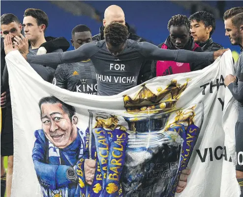  ?? OLI SCARFF/AFP/GETTY IMAGES ?? Leicester City’s James Maddison, right, and Demarai Gray hold a banner Saturday showing club chairman Vichai Srivaddhan­aprabha following their Premier League match against Cardiff City in Wales.