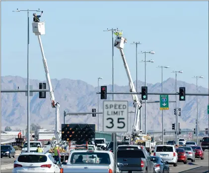  ?? Buy this photo at YumaSun.com PHOTO BY RANDY HOEFT/YUMA SUN ?? TECHNICIAN­S INSTALL NEW LED LIGHTS WEDNESDAY ON POLES LOCATED IN THE MEDIAN along 16th Street between Arizona Avenue and the bridge over Interstate 8. The city is in the process of refitting nearly 7,500 streetligh­ts with LED lighting.