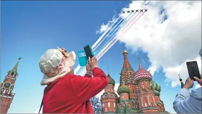  ?? PAVEL GOLOVKIN / ASSOCIATED PRESS ?? Visitors to Moscow’s Red Square take photos of jets flying over the Kremlin on Thursday during a rehearsal for Russia’s May 9 Victory Day military parade to mark the 72nd anniversar­y of winning World War II.