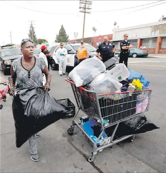  ?? Photograph­s by Francine Orr Los Angeles Times ?? BIG MAMA struggles to empty her tent before a city sanitation crew does a cleanup of the encampment. Twice she and her neighbors moved, but crews never showed up. After a third notice, residents didn’t pay attention, and they had to rush to comply.