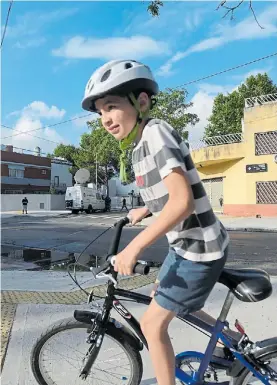  ??  ?? Vida robada. Brian Aguinaco paseando en bici por su barrio, Flores.