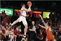  ?? AP Photo/Charlie Neibergall ?? Iowa State guard Caleb Grill catches a pass over Texas guard Avery Benson (21) during the second half of an NCAA college basketball game Saturday in Ames, Iowa. Iowa State won, 79-70.