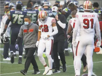  ?? Scott Eklund / Associated Press ?? Dante Pettis ( 18) leaves the field with a shoulder injury after he lost a fumble on a kickoff return in the 49ers’ 3727 loss at Seattle on Sunday. That was his final play with the Niners.