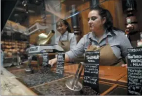  ?? AP PHOTO/LUCA BRUNO ?? Employees work at the Starbucks store in Milan, Italy. Starbucks opens its first store in Italy Friday, betting that premium brews and novelties like a heated marble-topped coffee bar will win patrons in a country fond of its espresso rituals. Decades ago, Milan’s coffee bars had inspired the chain’s vision.