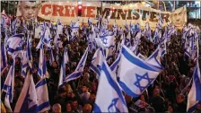  ?? PHOTO BY JACK GUEZ — AFP VIA GETTY IMAGES ?? Israeli protesters lift national flags as they rally in central Tel Aviv, earlier this month against controvers­ial legal reforms being touted by the government.