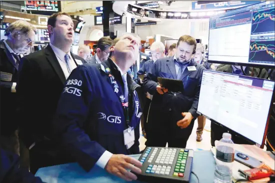  ?? (AP) ?? In this file photo, Specialist Glenn Carell (center), works with traders at the post that handles NIO, a Chinese automobile manufactur­er, on the floor of the New York Stock Exchange. Investors poured a net $20.6 billion into sustainabl­e funds across the industry last year, nearly quadruple the record set a year earlier, according to Morningsta­r. Investors, particular­ly younger ones,
increasing­ly say they want their money invested with an eye toward sustainabi­lity.