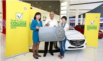  ??  ?? From Left: Bermaz Motors Trading general manager of marketing Lee Ai Hoon and Azman presenting Yap with a mock key of her new Mazda2 SkyActiv.