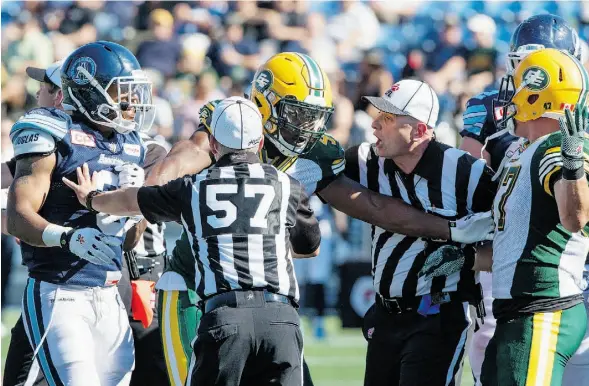  ?? AMBER BRACKEN/THE CANADIAN PRESS/FILE ?? CFL referees, like the players, are adjusting to new rules this season. Here referees and Edmonton Eskimos Odell Willis try to break up Toronto Argonaut Brandon Whitaker and Eskimo JC Sherritt during the June 27 game in Fort McMurray. The Argos won...