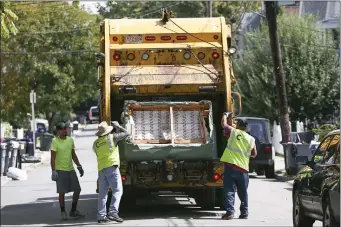  ?? NICOLAUS CZARNECKI/BOSTON HERALD ?? A trash collection crew works in Allston in this Aug. 29, 2019, file photo.