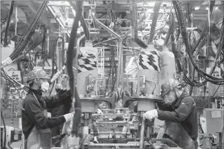  ?? GIULIA MARCHI / THE NEW YORK TIMES ?? Workers keep busy in the body shop of the Ford plant in Hangzhou, China. Ford said last month that it would move production of its Focus sedan to China from Michigan. A downturn in U.S. car sales after two record years is prompting companies to scale...