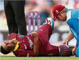  ??  ?? Too much to bear: West Indies’ Evin Lewis receiving medical attention after sustaining an injury during the fourth one-day internatio­nal against England on Wednesday. — Reuters