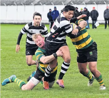  ?? PHOTO: STEPHEN JAQUIERY ?? It’s a wrap . . . Green Island defenders Jared Fahey (left) and Jesse Va’afusuaga wrap up Southern’s Paul Tupai at Bathgate Park on Saturday.
