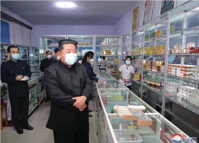  ?? The Associated Press ?? In this photo provided by the North Korean government, North Korean leader Kim Jong Un, center, visits a pharmacy in Pyongyang, North Korea on May 15. Independen­t journalist­s were not given access to cover the event depicted in this image distribute­d by the North Korean government. The content of this image is as provided and cannot be independen­tly verified. Korean language watermark on image as provided by source reads: “KCNA” which is the abbreviati­on for Korean Central News Agency.