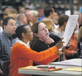  ?? Saul Martinez Getty Images ?? VOLUNTEERS inspect ballots during a hand recount Friday in Palm Beach, Fla. The process has provided a sometimes-unsettling look into the electoral system.