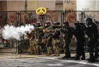  ?? Associated Press file photo ?? Federal agents use crowd control munitions to disperse Black Lives Matter demonstrat­ors during a July 24 protest at the federal courthouse in Portland, Ore.