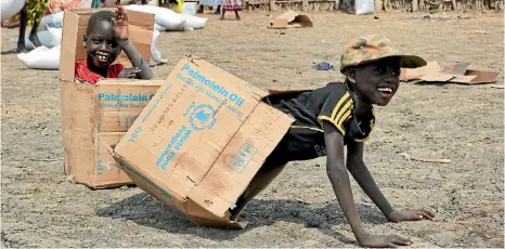  ?? PHOTO: AP ?? Children play in empty cardboard boxes during a food distributi­on by Oxfam outside Akobo town, one of the last rebelheld stronghold­s in South Sudan. Child abductions have risen during South Sudan’s civil war as desperate people try to make a living,...