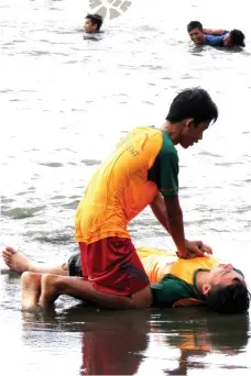  ??  ?? BASIC SKILLS. A scout simulates a mouth-to-mouth resuscitat­ion for a drowning victim.
