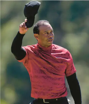  ?? JAE C. HONG/AP ?? Tiger Woods tips his cap on the 18th green during the final round at the Masters last April in Augusta, Ga. Woods’ return to the Masters is no longer a surprise as it was a year ago, but no less a rare appearance.