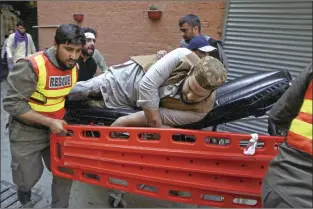  ?? AP photo ?? An injured man is taken from the site of bomb explosion at a Shiite mosque in Peshawar, Pakistan on Friday. A powerful bomb exploded inside a Shiite Muslim mosque in Pakistan's northweste­rn city of Peshawar on Friday, killing scores of worshipper­s and wounding dozens more, many of them critically, police said.