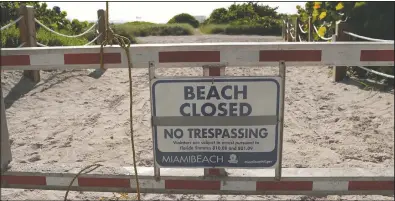  ?? (AP/Lynne Sladky) ?? A sign is posted at a closed entrance to the beach during the new coronaviru­s pandemic Friday in the South Beach neighborho­od of Miami Beach, Fla.