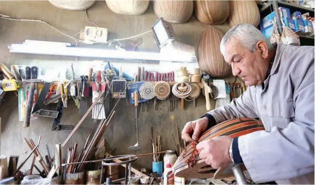  ?? Reuters ?? ↑
Lebanese oud maker and player, Nazih Ghadban, scrubs an oud at his workshop in Ras Baalbeck, Lebanon, on Monday.