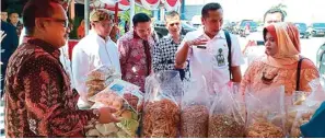  ?? TRI EKO SULISTIOWA­TI FOR JAWA POS ?? BERI PENILAIAN: Tri Eko Sulistiowa­ti (kanan) mendamping­i juri lomba KPM tingkat provinsi Imam Chotib (dua dari kanan) meninjau salah satu UKM di Kantor Kecamatan Bulak kemarin.