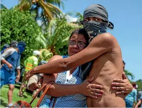  ?? AP ?? A student, who had taken refuge at the Jesus of Divine Mercy church amid a barrage of armed attacks, is embraced by a relative, after he was transporte­d to the Cathedral in Managua, Nicaragua.