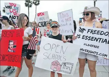  ?? Raul Roa Los Angels Times ?? A BOY holds a sign urging schools to be opened during a protest May 9. Most California schools are expected to open in late August or September, and some will offer a combinatio­n of in-person and distance learning.