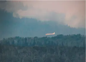  ?? CP PHOTO ?? A tanker circles overhead before dropping retardant while battling the Shovel Lake wildfire near Fraser Lake.