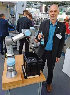  ?? FOTO: WARSCHEID ?? DFKI-Forscher Tim Schwartz mit einem neu konzipiert­en Roboter, der auf Wunsch auch Kaltgeträn­ke reicht.