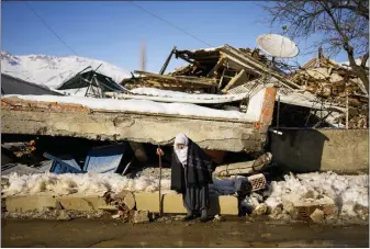  ?? FRANCISCO SECO/ASSOCIATED PRESS ?? Turkish Zehra Kurukafa walks past a destroyed house in the village of Polat, Turkey, Sunday, Feb. 12, 2023. Five days after two powerful earthquake­s hours apart caused scores of buildings to collapse, killing thousands of people and leaving millions homeless, rescuers were still pulling unlikely survivors from the ruins.