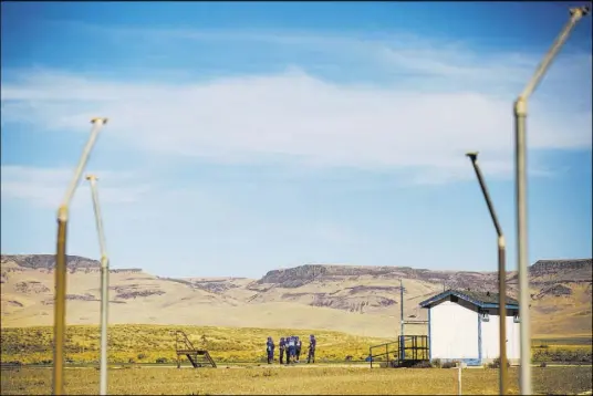  ?? Chase Stevens Las Vegas Review-Journal @csstevensp­hoto ?? Football players gather for practice Sept. 25 at McDermitt Combined School in McDermitt. The restroom, right, was built by the school’s shop class, one of few amenities on the field.